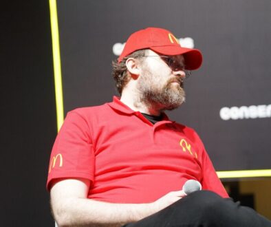 Cardano founder Charles Hoskinson speaking on stage at a crypto conference