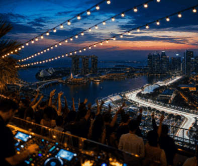 Rooftop party above Marina Bay at dusk with the illuminated street circuit below